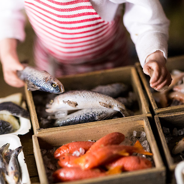 Close up of a wooden boxes full of fresh fish at a fish market