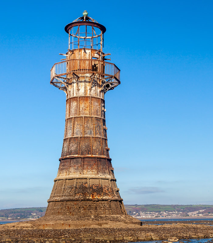 Shot of an old lighthouse with blue sky in the background 