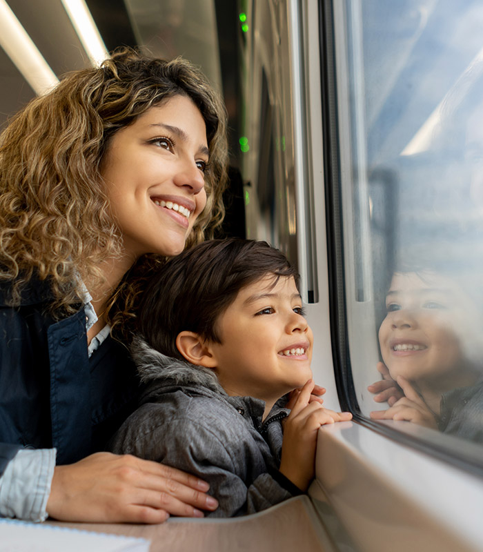 A woman and her son sat on a train looking out the window 