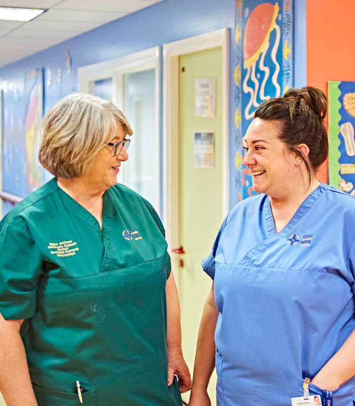 Two nurses looking at eachother, smiling 