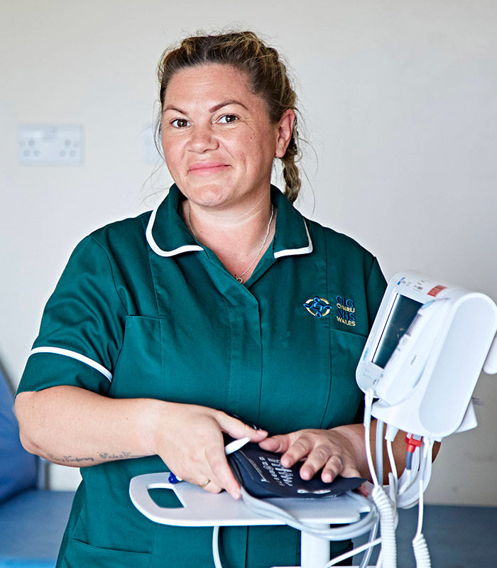 Woman nurse touching medical equipement and smiling at camera